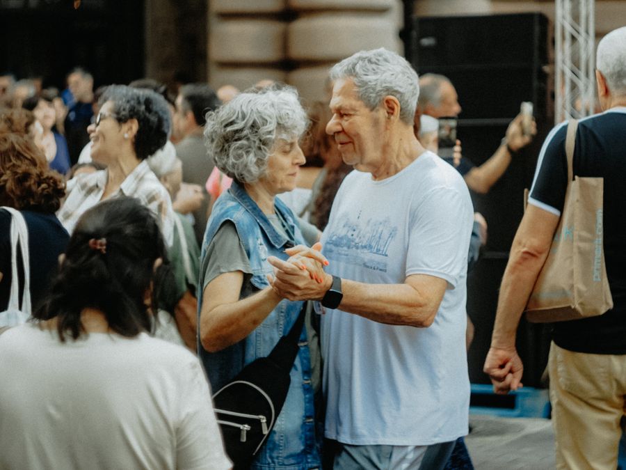 A senior couple dancing joyfully at an outdoor gathering